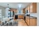 Bright kitchen with stainless steel appliances, wooden cabinets, and adjacent dining area for easy meal prep and enjoyment at 9435 E 108Th Pl, Commerce City, CO 80640