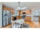 Well-lit kitchen features stainless steel appliances, warm wooden cabinets, and a cozy dining area with natural light at 9435 E 108Th Pl, Commerce City, CO 80640