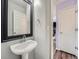 Elegant powder room featuring a pedestal sink, decorative mirror, and clean, neutral paint colors at 8793 Cloverleaf Cir, Parker, CO 80134