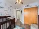 Bedroom featuring closet and ocean themed wall decals, a dark wood changing table and wood-look floors at 8793 Cloverleaf Cir, Parker, CO 80134