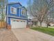 Blue two-story home with a white garage door and front lawn on a sunny day at 8793 Cloverleaf Cir, Parker, CO 80134