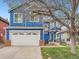 Charming blue two-story home with a large front lawn, white garage door, and mature tree at 8793 Cloverleaf Cir, Parker, CO 80134