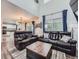 Bright and airy living room with soaring ceilings, leather sofas, and views into kitchen at 8793 Cloverleaf Cir, Parker, CO 80134