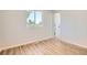 Bright bedroom featuring hardwood floors, a window, and a white door leading to the rest of the home at 16273 E Brown Pl, Aurora, CO 80013