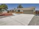 Charming single-story home with a well-maintained yard and long driveway leading to an attached garage at 16273 E Brown Pl, Aurora, CO 80013