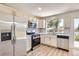 Updated kitchen with stainless steel appliances, white cabinetry, and a window providing natural light at 16273 E Brown Pl, Aurora, CO 80013