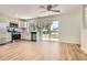 Spacious kitchen with stainless steel appliances, white cabinets, and wood flooring, flowing into the living area at 16273 E Brown Pl, Aurora, CO 80013
