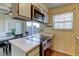 Bright kitchen features modern stainless steel appliances, tile countertops, and window at 1865 Terry St # 3, Longmont, CO 80501