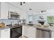 Bright kitchen featuring stainless steel appliances, granite counters, and stylish white cabinetry at 8500 E Jefferson Ave # 16B, Denver, CO 80237