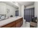 Bathroom with a long vanity, large mirror, linen closet, and a shower-tub combination with curtain at 2860 Calkins Pl, Broomfield, CO 80020