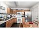 Kitchen with oak cabinets, stainless steel refrigerator, and a dining area with wooden table and chairs at 2860 Calkins Pl, Broomfield, CO 80020