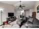 Open living room featuring vaulted ceiling, ceiling fan, comfortable seating, and a TV with shelving at 2860 Calkins Pl, Broomfield, CO 80020