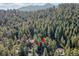 Aeral view of wooded property featuring a home nestled among towering trees at 26378 S End Rd, Kittredge, CO 80457