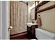 Cozy bathroom with dark wood floors, a pedestal sink, and storage shelves at 26378 S End Rd, Kittredge, CO 80457
