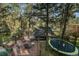 Spacious deck with outdoor seating, overlooking a trampoline surrounded by lush trees at 26378 S End Rd, Kittredge, CO 80457