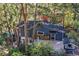 Overhead view of the house with a patio, showing stacked firewood and surrounding trees at 26378 S End Rd, Kittredge, CO 80457