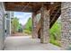 Outdoor patio area with stone pillars supporting the upper deck and views of lush greenery at 4421 Tanager Trl, Broomfield, CO 80023
