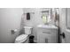 Modern half bathroom featuring a stylish vanity with storage, round mirror, and neutral walls at 4421 Tanager Trl, Broomfield, CO 80023