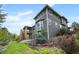 Stunning multi-story home with green siding, expansive windows, and a beautifully landscaped yard at 4421 Tanager Trl, Broomfield, CO 80023