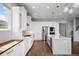 Bright kitchen featuring a large island, stainless steel appliances, white cabinets, and hardwood floors at 4421 Tanager Trl, Broomfield, CO 80023
