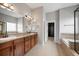 En-suite bathroom featuring dual sinks, granite counters, and a separate soaking tub and walk-in closet at 4421 Tanager Trl, Broomfield, CO 80023