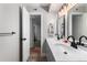 This bathroom features a double sink vanity with modern fixtures and access to bedroom and hallway at 12131 Melody Dr # 101, Denver, CO 80234