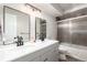 This bright bathroom includes double sinks, modern vanity, and bathtub with shower at 12131 Melody Dr # 101, Denver, CO 80234