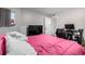 The bedroom features a plush pink comforter, light-filled window, and entertainment center with wall-mounted television at 12131 Melody Dr # 101, Denver, CO 80234