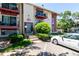 Two-story apartment building with updated red trim and lush landscaping at 12131 Melody Dr # 101, Denver, CO 80234