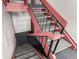 Interior staircase featuring gray carpet and red and black railings at 12131 Melody Dr # 101, Denver, CO 80234