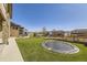 Expansive backyard with artificial turf, stone patio, in-ground trampoline, and manicured landscaping at 9559 Yucca Way, Arvada, CO 80007