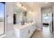 Stylish bathroom featuring double sinks, vanity, and tile flooring with a walk-in closet at 9559 Yucca Way, Arvada, CO 80007