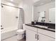 Modern bathroom featuring white subway tile, dark hardware, and sleek vanity with granite countertop at 9559 Yucca Way, Arvada, CO 80007