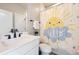 Bright bathroom featuring modern white vanity, black hardware, and cheerful sunny shower curtain at 9559 Yucca Way, Arvada, CO 80007