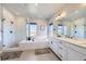 Bright bathroom with a soaking tub, walk-in shower, and dual vanity with modern fixtures at 9559 Yucca Way, Arvada, CO 80007