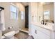 Contemporary bathroom with tiled shower, glass door, modern vanity, and natural light at 9559 Yucca Way, Arvada, CO 80007