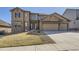 Beautiful two-story home with a stone and siding exterior, three-car garage, and landscaped front yard at 9559 Yucca Way, Arvada, CO 80007