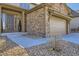Close up of home's front entry and garage showing decorative stone exterior and drought resistant landscaping at 9559 Yucca Way, Arvada, CO 80007