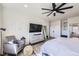 Comfortable bedroom features a sitting area, ceiling fan, and view to an ensuite bathroom at 9559 Yucca Way, Arvada, CO 80007