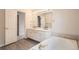 Bright bathroom features double sink vanity with large mirror, soaking tub, and modern fixtures at 16645 W 2Nd Ave, Golden, CO 80401