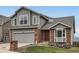 Charming two-story home featuring a brick and gray wood exterior with a two-car garage at 16645 W 2Nd Ave, Golden, CO 80401
