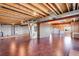 Unfinished basement with exposed ceiling, wood flooring, and potential for customization at 9239 Erminedale Dr, Lone Tree, CO 80124