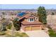 Home featuring three car garage, solar panels, and manicured front yard at 9239 Erminedale Dr, Lone Tree, CO 80124