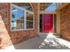 Close-up of a red front door framed by large windows and brick facade at 9239 Erminedale Dr, Lone Tree, CO 80124
