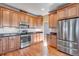 Well-lit kitchen featuring wooden cabinets, stainless steel appliances, granite countertops, and hardwood flooring at 9239 Erminedale Dr, Lone Tree, CO 80124