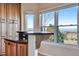 Bright kitchen area with wooden cabinets, granite countertops, and a scenic window view of the surrounding landscape at 9239 Erminedale Dr, Lone Tree, CO 80124