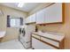 Functional laundry room with a washer, dryer, utility sink, white cabinets, and a window for natural light at 9239 Erminedale Dr, Lone Tree, CO 80124