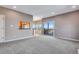 Bright living room with neutral walls, plush gray carpet, and a sliding glass door leading to a deck with scenic views at 9239 Erminedale Dr, Lone Tree, CO 80124