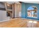 Bright living room with hardwood floors, large window, and open staircase at 9239 Erminedale Dr, Lone Tree, CO 80124