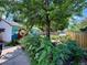 Backyard featuring a playhouse and a muraled building, surrounded by lush greenery and mature trees at 1341 Chester St, Aurora, CO 80010